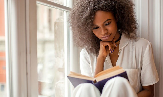 small ad Woman reading in a window seat